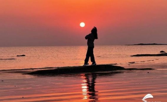 海上日出与追光者的身影